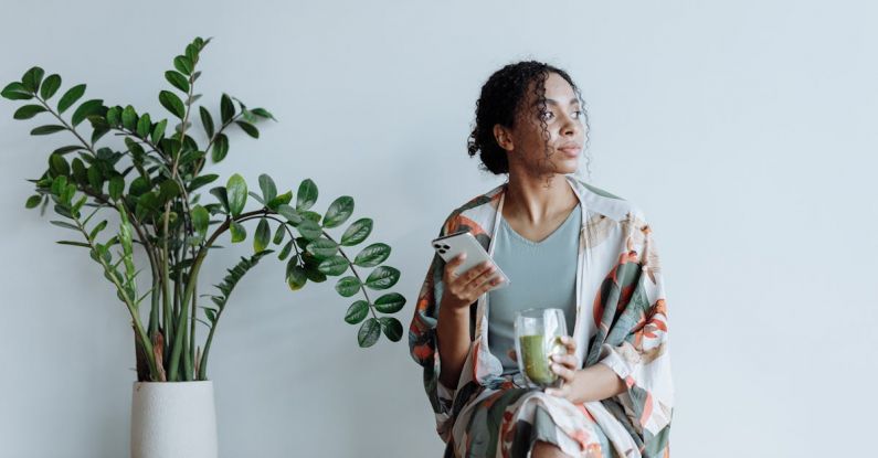 Unwind - Photo of Woman Sitting Beside an Indoor Plant