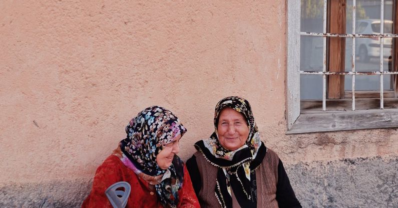 Stuck Window - Two women sitting on the ground with a cane