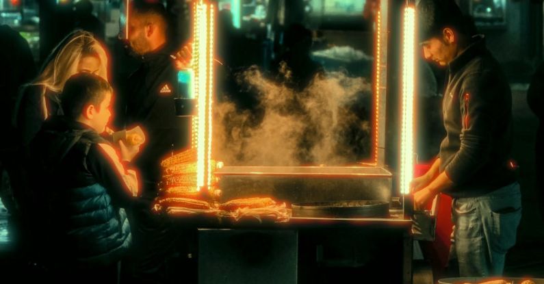 Buying In Bulk - A group of people standing around a food cart