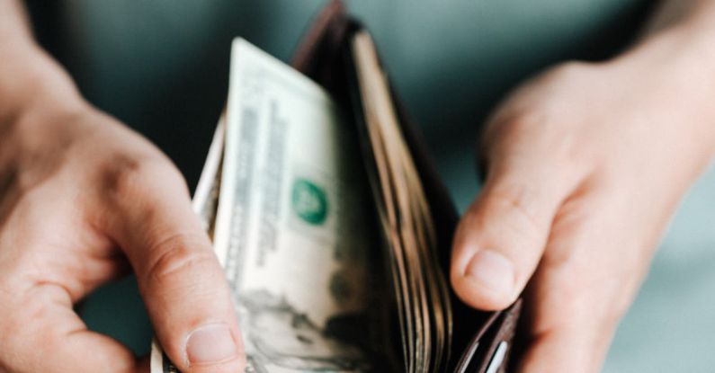 Value For Money - Crop man getting dollars from wallet