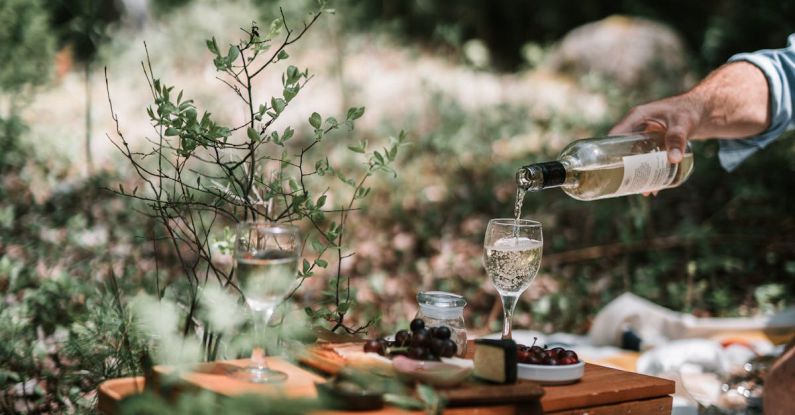 Container Garden - Person Pouring Wine On A Glass Above A Wicker Basket